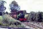 Bagnall 0-4-0ST ‘Woto’ approaches a level crossing over a minor road as it nears Stonehenge Works   (10/09/1994)