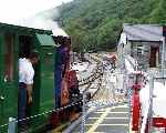 ‘Elidir’ runs across the level crossing and in to the loop at Gilfach Ddu, heading for Penllyn.   (06/08/2003)