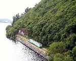 ‘Thomas Bach’ heads out alongside the lake with a train for Penllyn.   (06/08/2003)