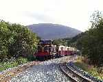 Running into Waunfawr from the south, Caernarfon Castle and train   (26/09/2003)